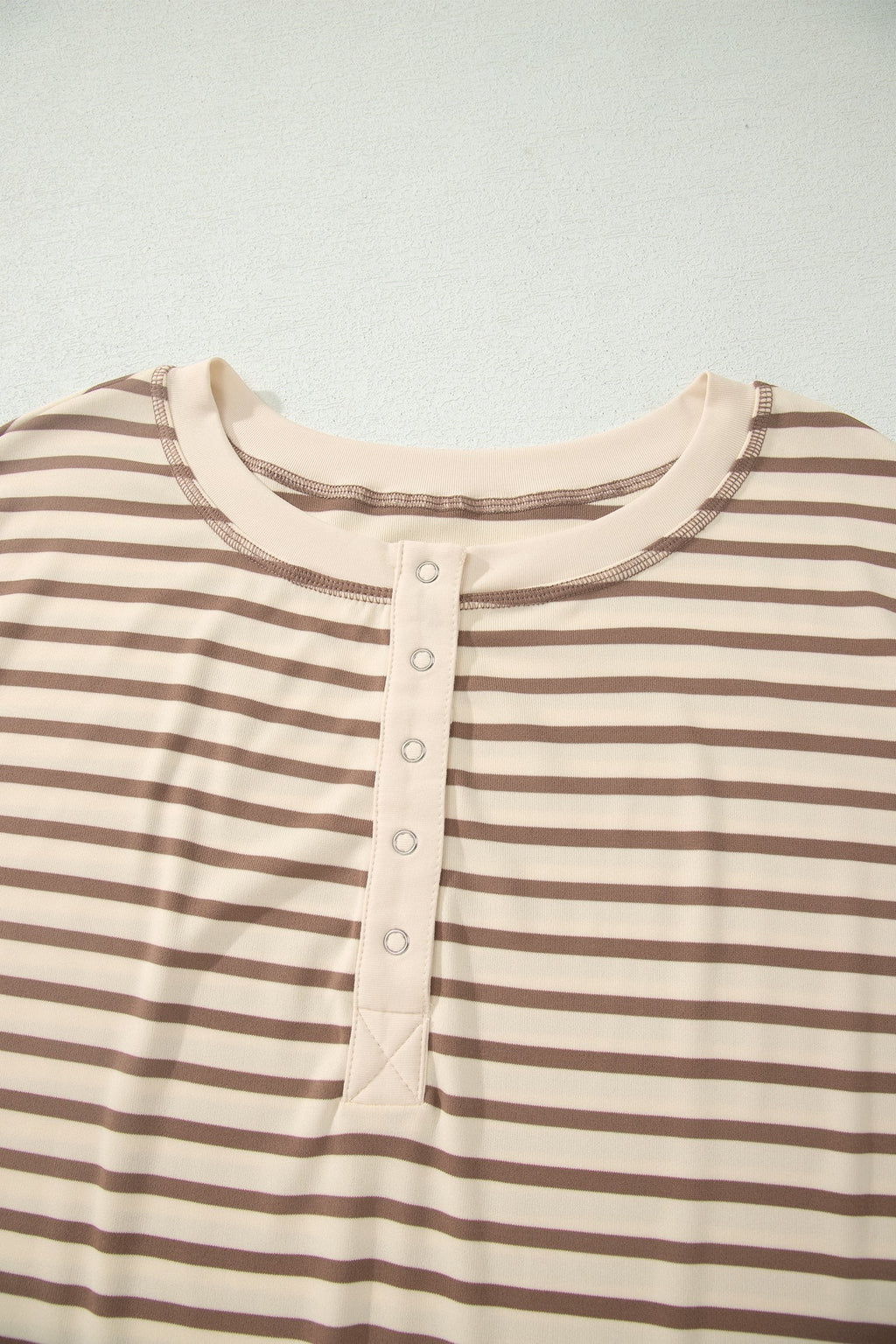 Somethinguluv3 brown and cream striped top with a round neckline and metal button placket detail