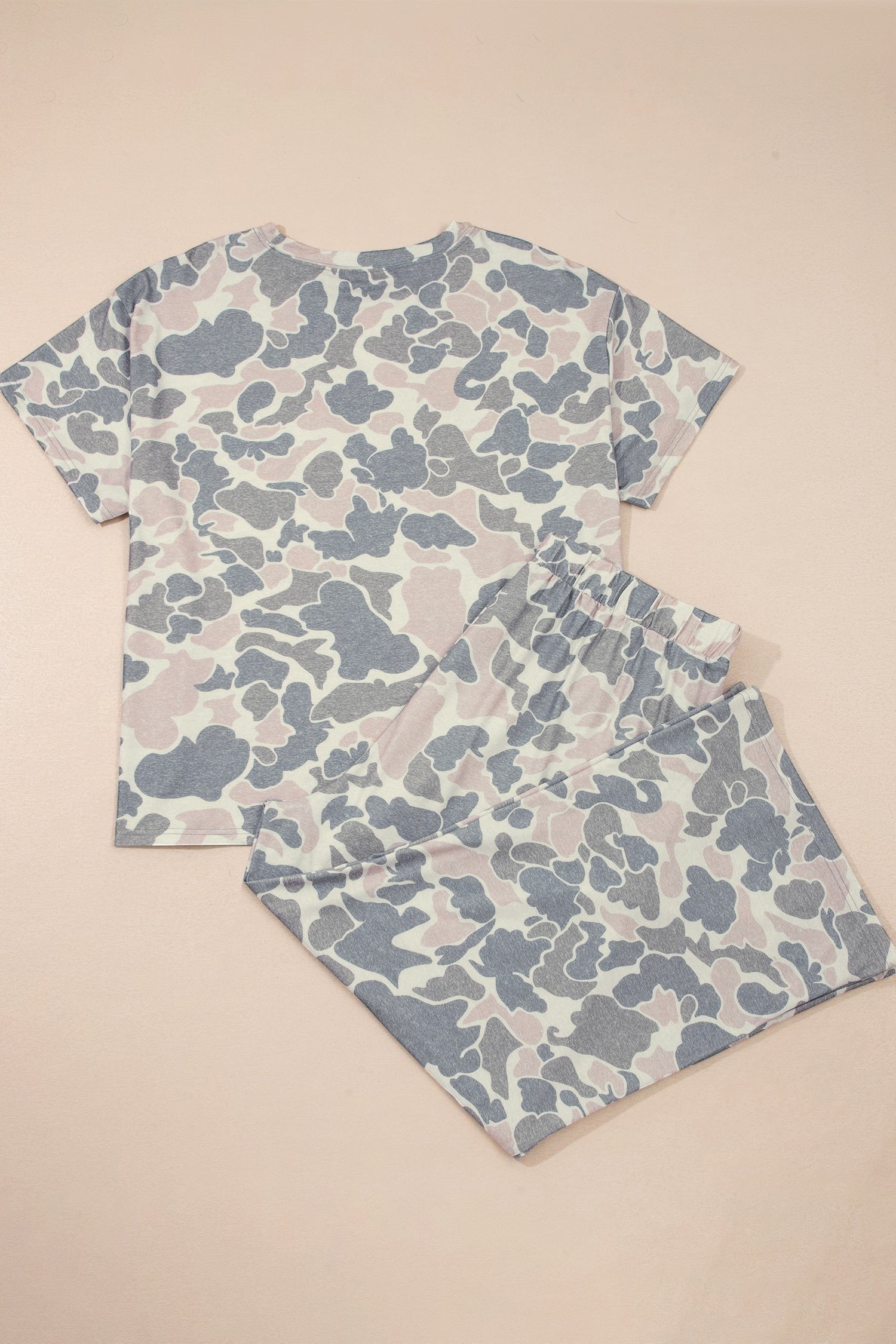 Somethinguluv3 two-piece lounge set featuring a muted camo print short-sleeve top and wide-leg trousers in soft tones.