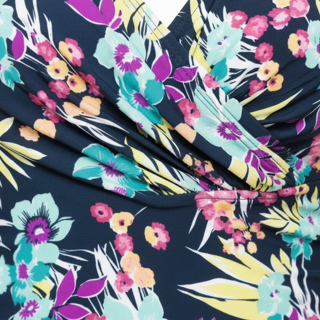 Somethinguluv3 floral and black one-piece swimsuit featuring a ruched waist and vibrant tropical flower print.