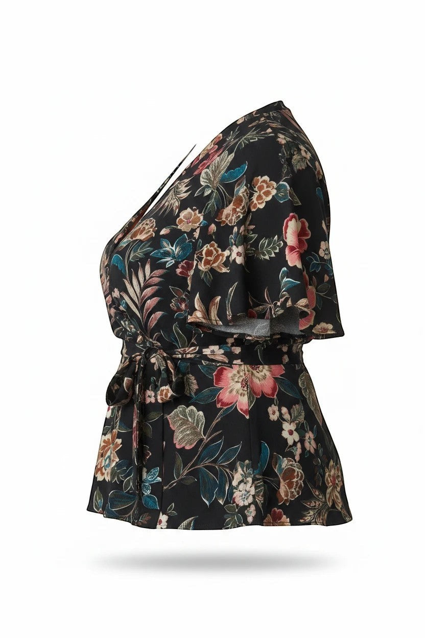 Somethinguluv3 black wrap blouse with multi-colored floral print, flutter sleeves, and waist tie, side view.