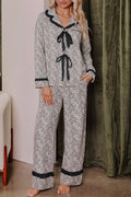 Somethinguluv3 two-piece pajama set with leopard print, long sleeves, black trim, and front bow knot details. Plus size boutique