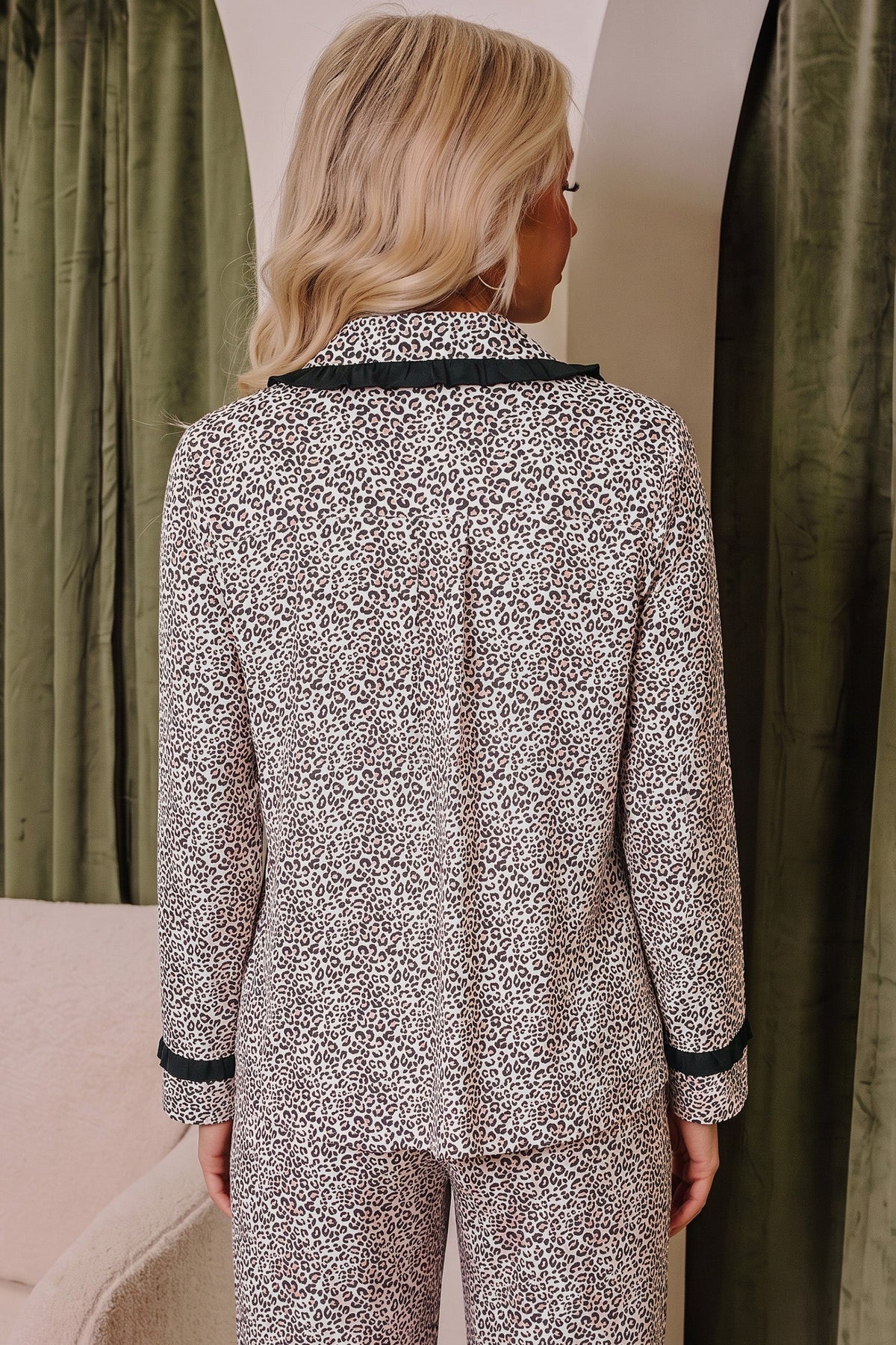 Somethinguluv3 two-piece pajama set with leopard print, long sleeves, and black trim, viewed from the back.