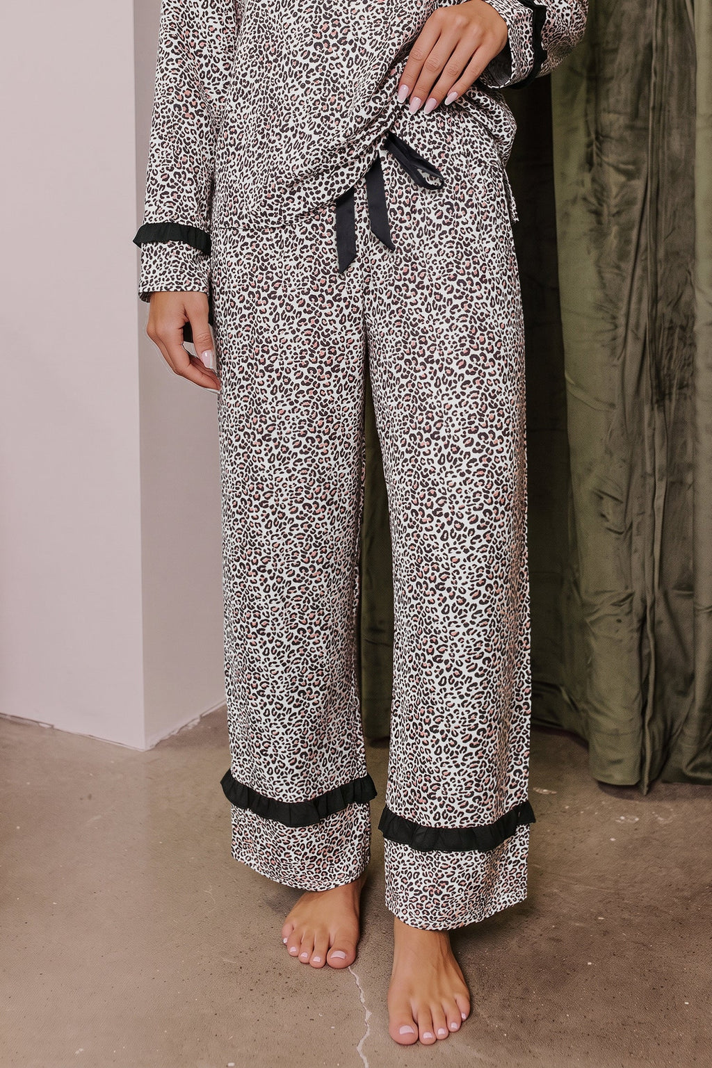 Somethinguluv3 leopard print two-piece pajama set with long sleeves, black trim, and a feminine bow knot detail.
