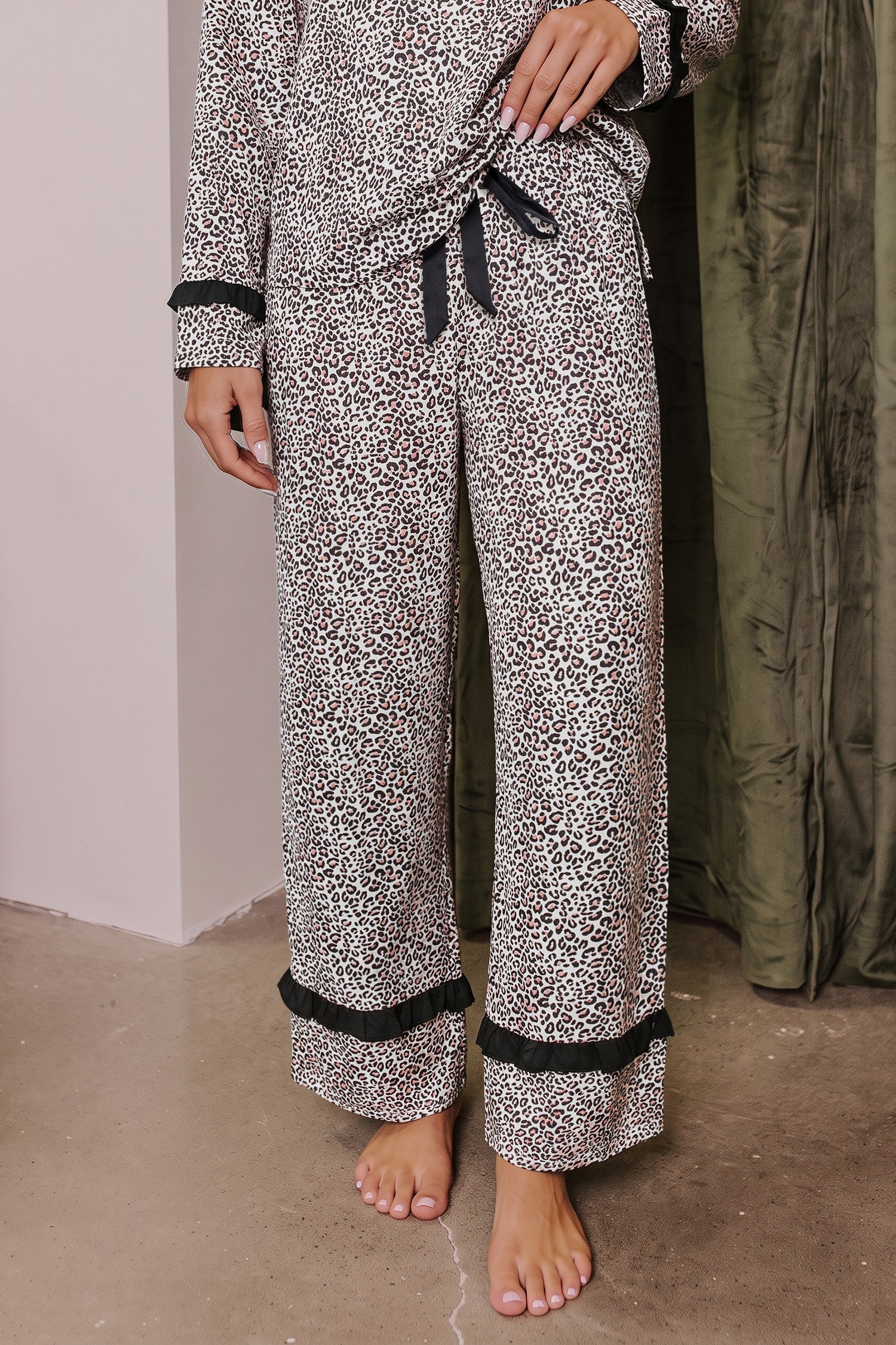 Somethinguluv3 leopard print two-piece pajama set with long sleeves, black trim, and a feminine bow knot detail.