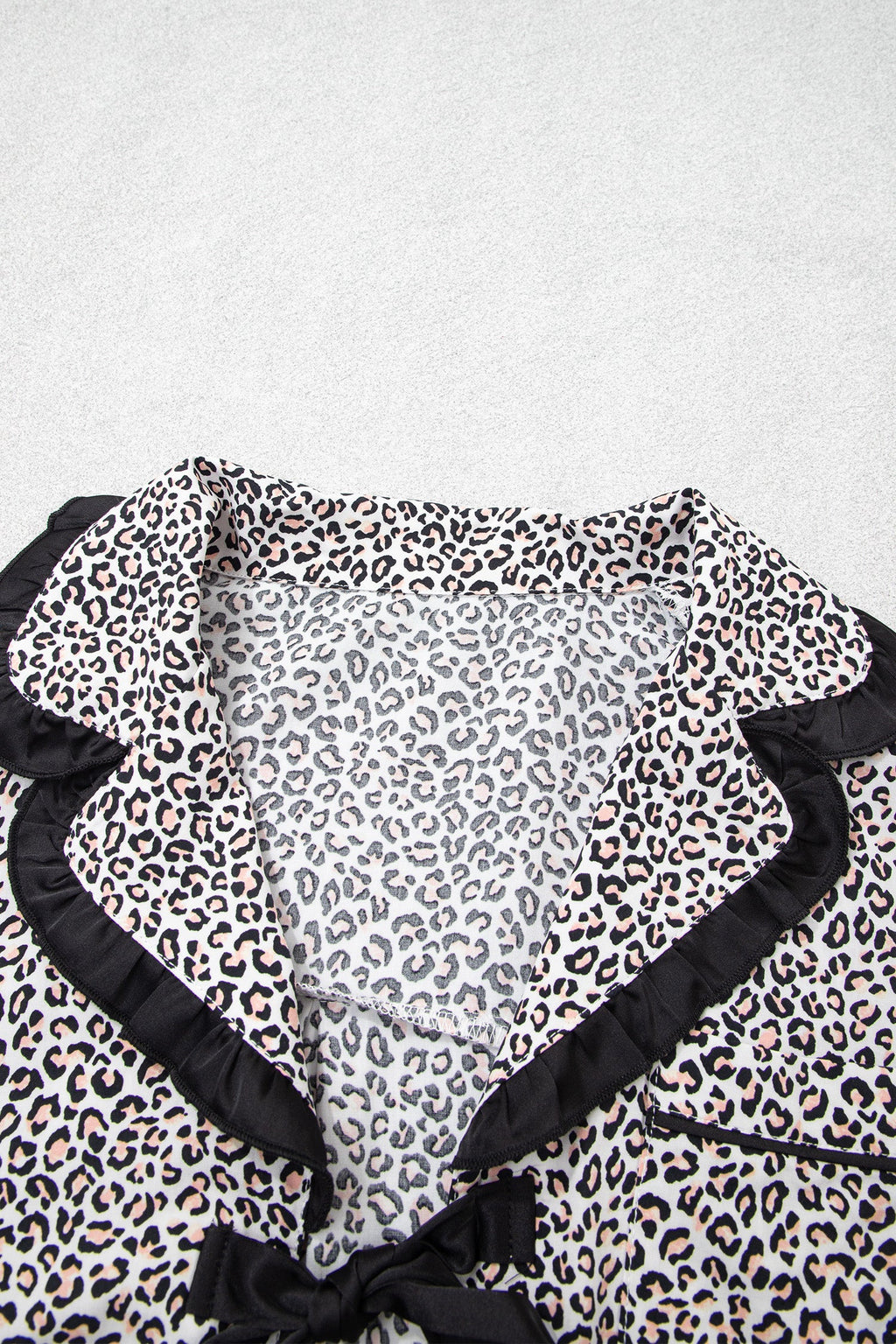 Somethinguluv3 leopard print pajama top with black ruffled trim and a feminine bow knot detail at the collar