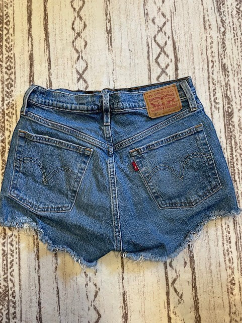 Somethinguluv3 vintage Levis 501 medium wash denim cut-off shorts with frayed hems and back pocket detail.