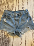 Somethinguluv3 vintage Levis 501 medium wash denim cut-off shorts with button fly and distressed frayed hem details.