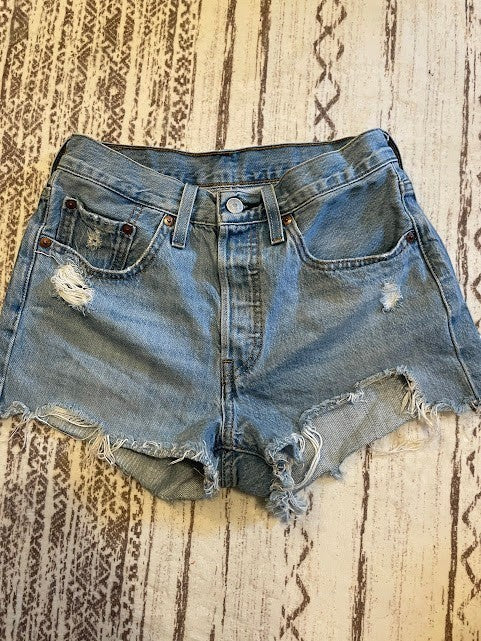 Somethinguluv3 vintage Levis 501 medium wash denim cut-off shorts with button fly and distressed frayed hem details.