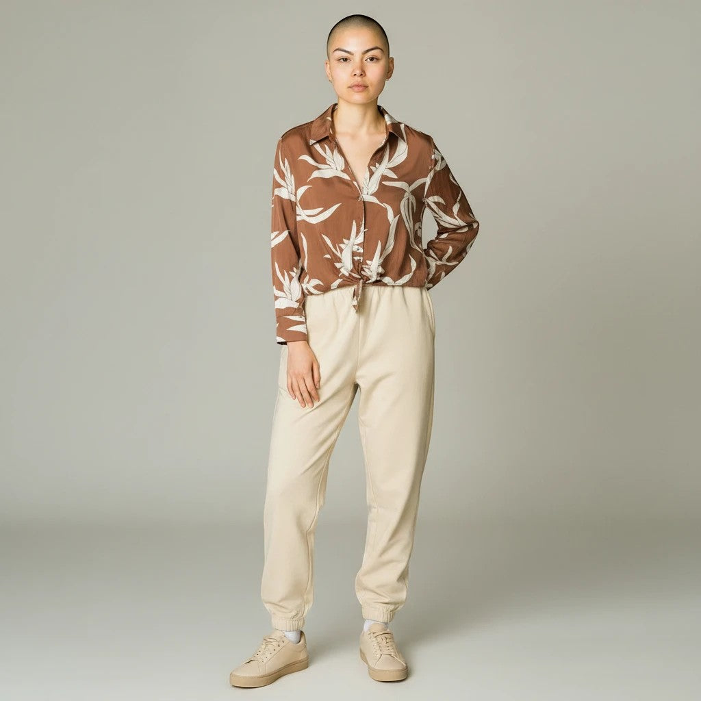 Somethinguluv3 mocha brown long sleeve button-down shirt with cream abstract leaf print and front-tie hem on a model