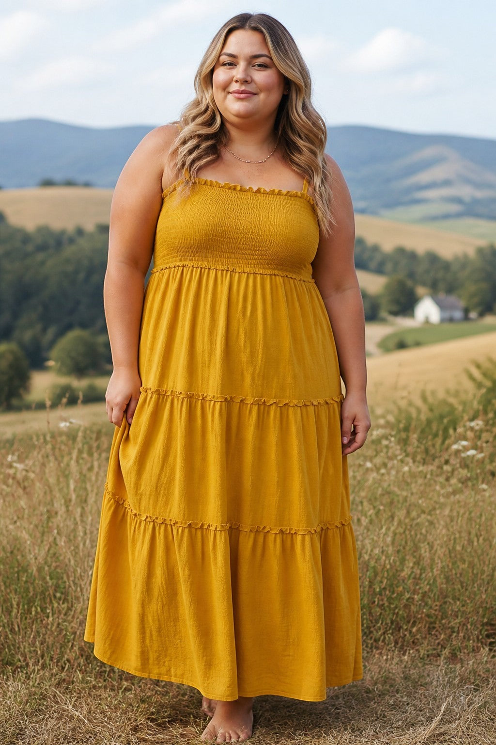 Somethinguluv3 mustard yellow cotton gauze tiered maxi dress with a smocked bodice and ruffled details on a model.