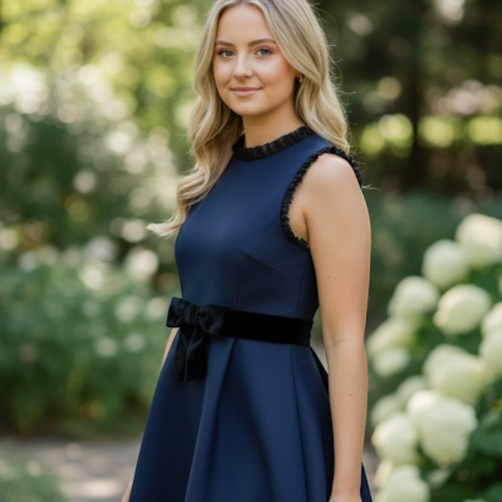 Somethinguluv3 navy blue sleeveless fit and flare dress with ruffled neckline and black velvet bow detail.