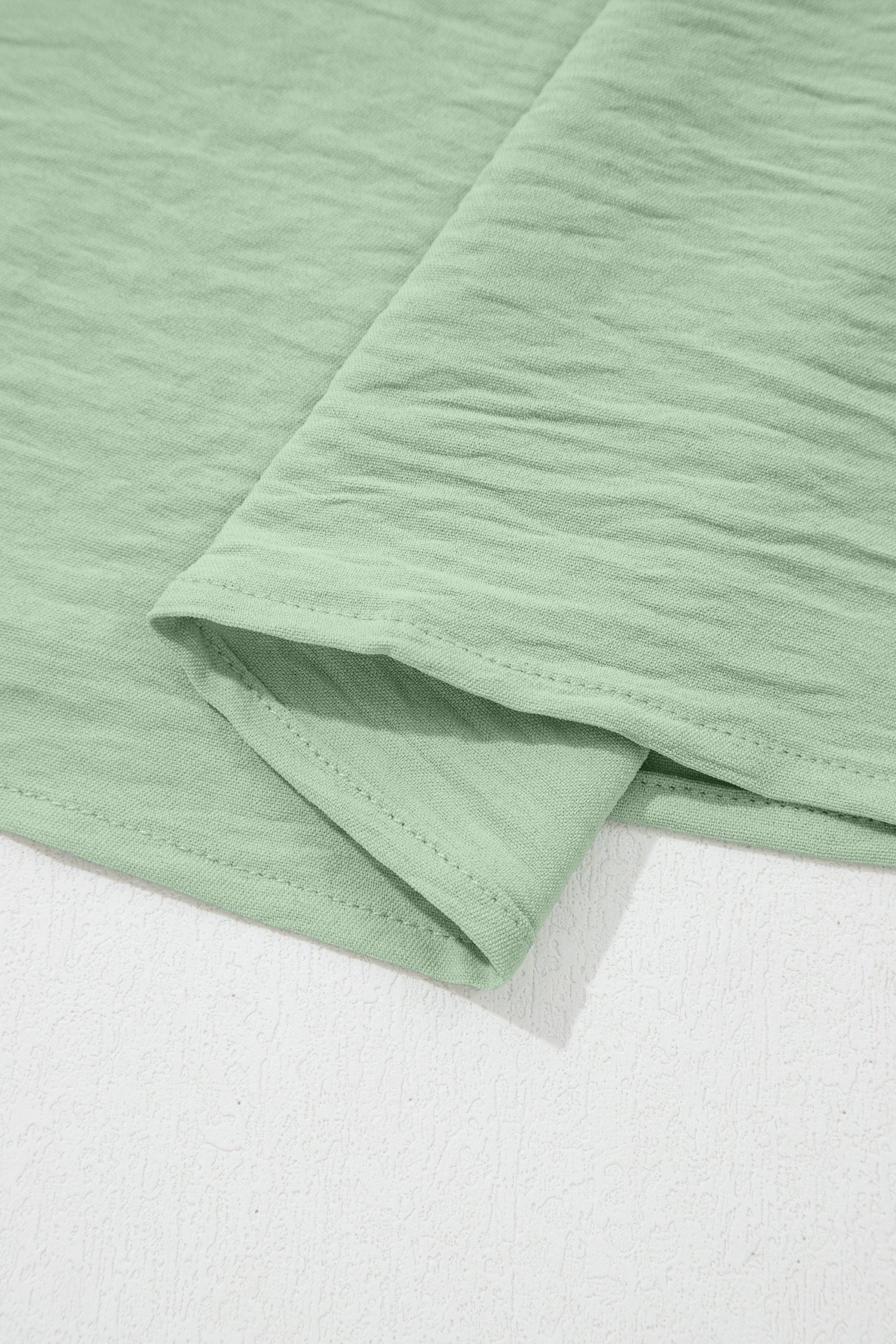 Somethinguluv3 plus size blouse in sage green with a textured fabric finish and hem detail.