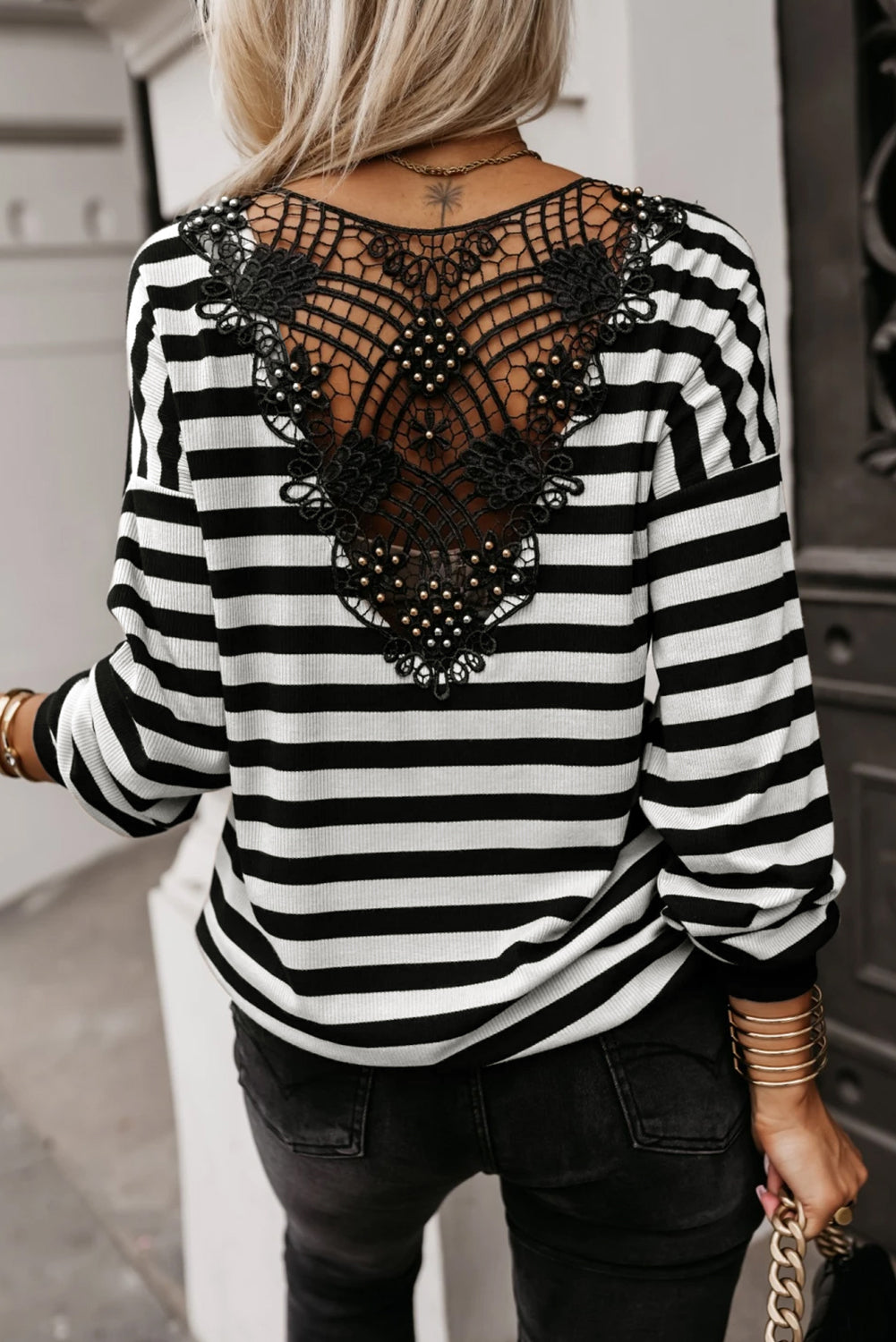 Somethinguluv3 black and white striped top featuring an intricate black crochet hollow-out back with button accents.