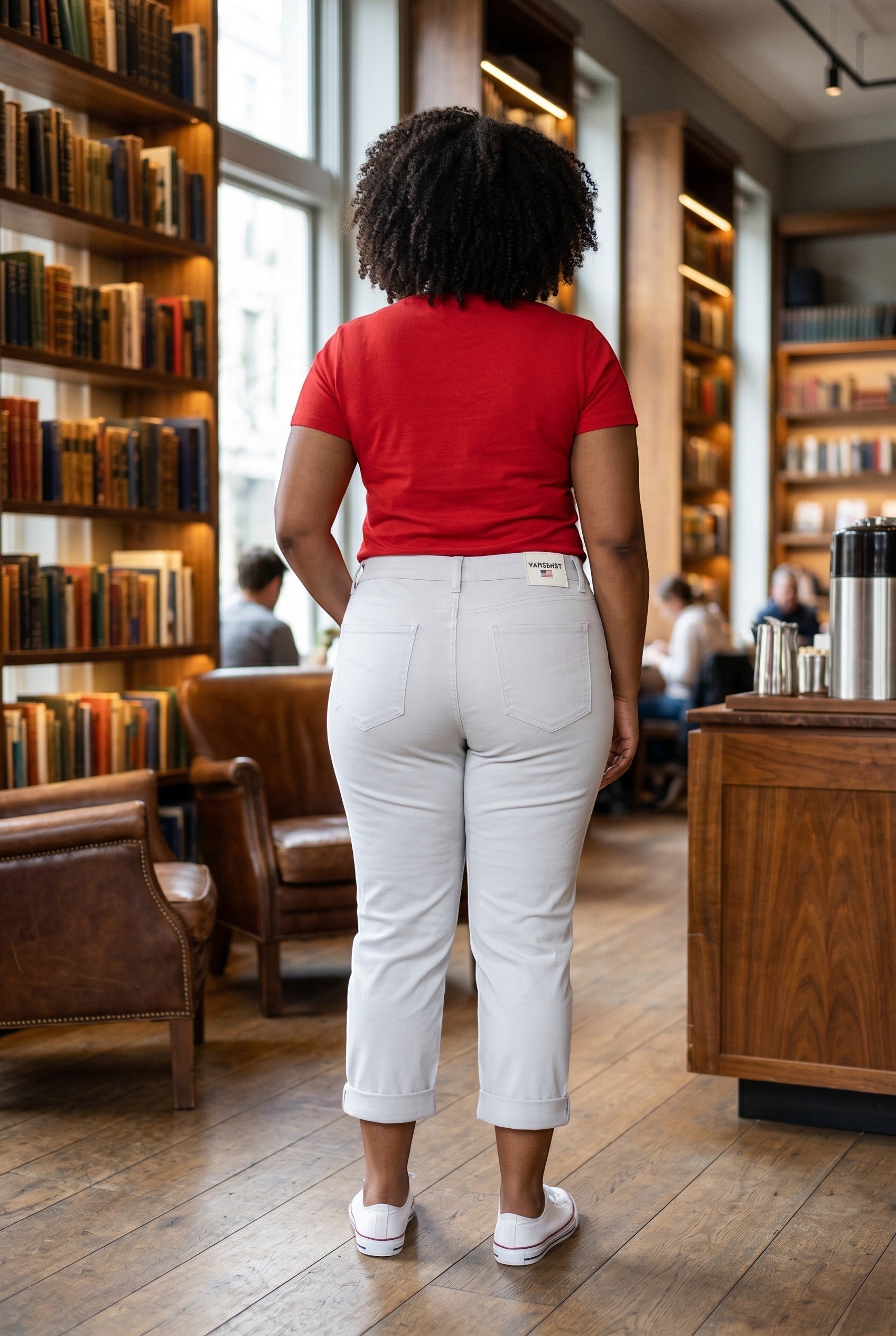Somethinguluv3 white distressed cropped denim pants worn by a woman with a red shirt in a library setting